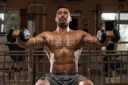 male bodybuilder doing shoulder press whit dumbbell Stock photo © Jasminko