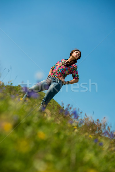 Bela mulher jeans em pé grama céu natureza Foto stock © Jasminko