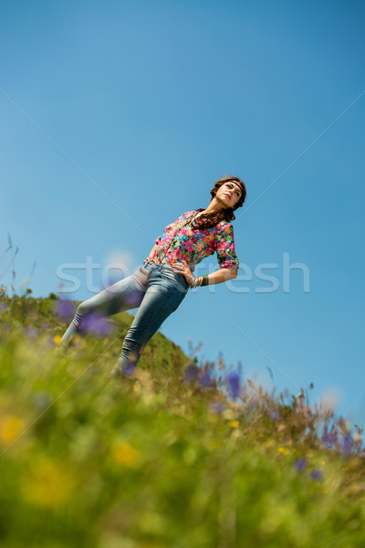 Bela mulher jeans em pé grama céu natureza Foto stock © Jasminko