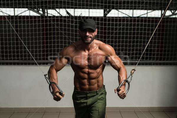Muscular Bodybuilder Performing Cable Crossover Stock photo © Jasminko