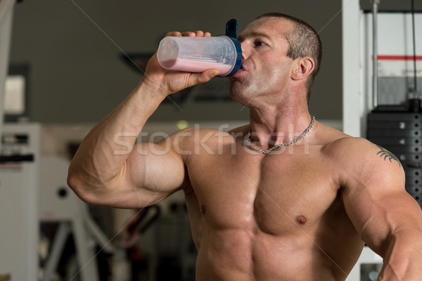 Muscular Man Drinking Water From Shaker Stock photo © Jasminko