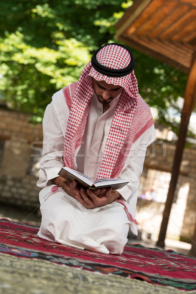 Muslim Man In Dishdasha Is Reading The Quran Stock photo © Jasminko
