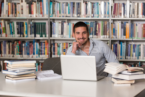 Jovem estudante usando laptop biblioteca bonito masculino Foto stock © Jasminko