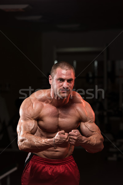 Jungen Bodybuilder Muskeln ernst stehen Fitnessstudio Stock foto © Jasminko