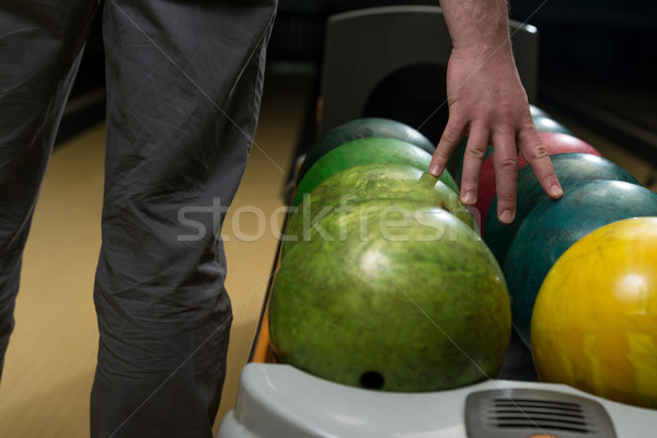 Stock photo: Holding Ball Against Bowling Alley