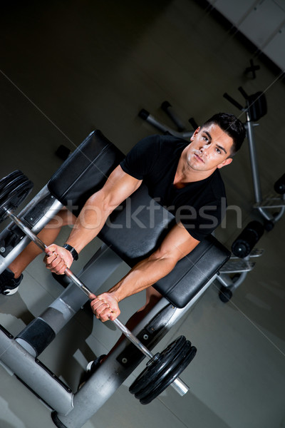 Handsome muscular man exercising in Gym Stock photo © Jasminko