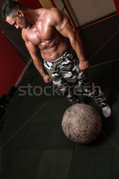 Muscular Man Resting After Picking Up A Stone Stock photo © Jasminko