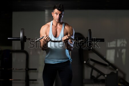 Men In The Gym Exercising Biceps With Barbell Stock photo © Jasminko
