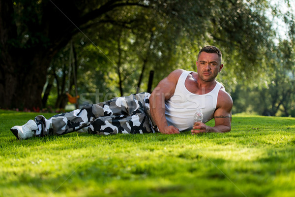 Bodybuilder Resting And Holding Water Bottle Stock photo © Jasminko