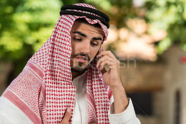 Bonito oriente médio homem falante telefone móvel jovem Foto stock © Jasminko