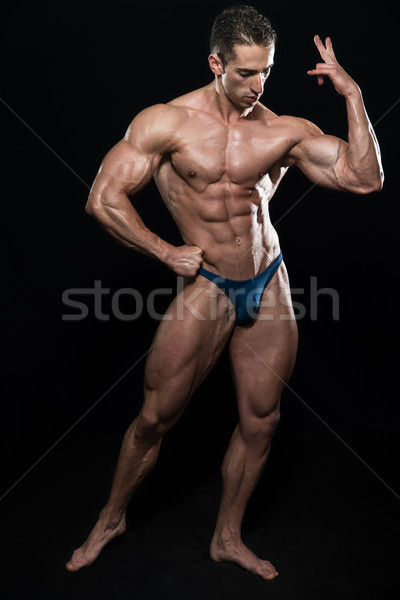 Muscular Men Flexing Muscles On Black Background Stock photo © Jasminko