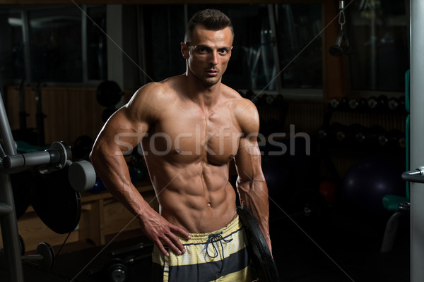 Handsome Muscular Men Holding Weight In His Arm Stock photo © Jasminko