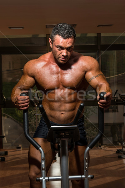 male bodybuilder using the elliptical machine Stock photo © Jasminko