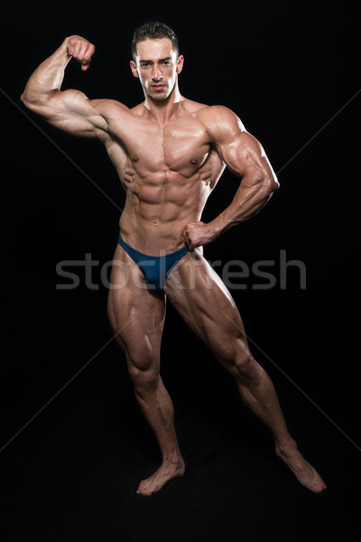 Muscular Men Flexing Muscles On Black Background Stock photo © Jasminko