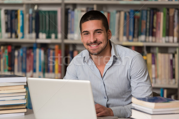 Młodych student za pomocą laptopa biblioteki przystojny mężczyzna Zdjęcia stock © Jasminko
