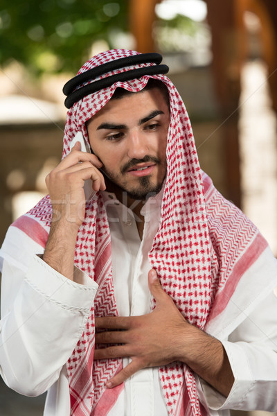 Cheerful Muslim Man Talking On Cell Phone Stock photo © Jasminko