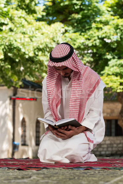 Muslim Man In Dishdasha Is Reading The Quran Stock photo © Jasminko