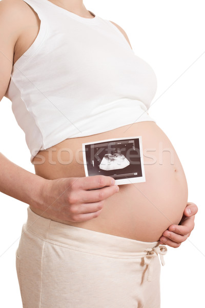 Stock photo: pregnant woman is holding a photo of her Ultrasound