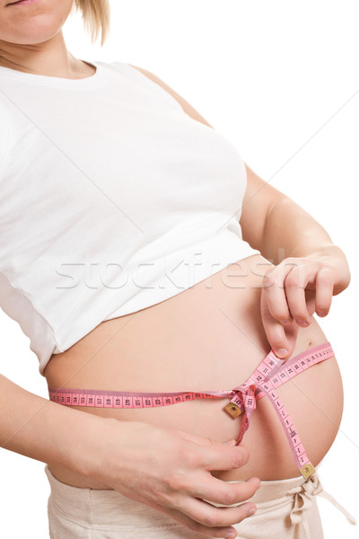 Stock photo: pregnant woman measures her belly