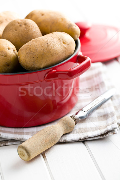 uncooked potatoes and old wooden peeler Stock photo © jirkaejc