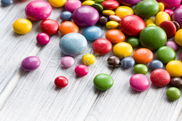 Három különböző színes cukorkák fa asztal csokoládé Stock fotó © jirkaejc