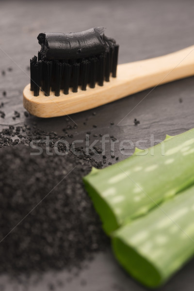 Foto stock: Escova · de · dentes · preto · carvão · vegetal · creme · dental · aloés · fundo