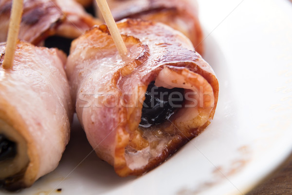 Baked prunes in bacon on a plate Stock photo © joannawnuk