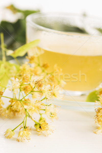 Stock photo: teapot and cup with linden tea and flowers