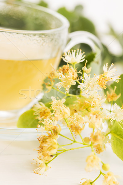 teapot and cup with linden tea and flowers Stock photo © joannawnuk