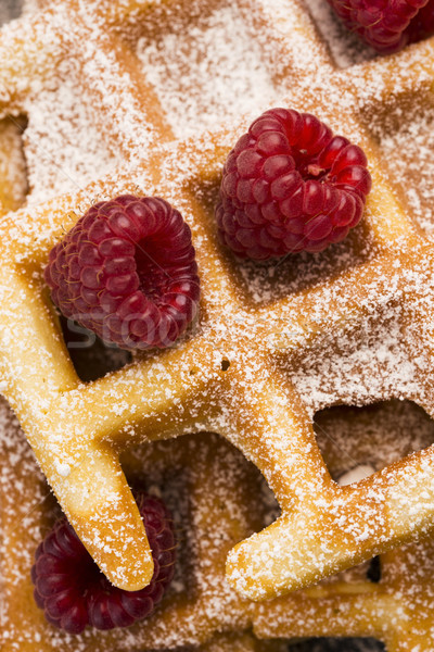 Stock photo: fresh waffles garnished with powdered sugar and raspberries 