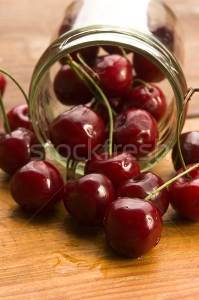 Cherry in glass jar isolated on the wooden background Stock photo © joannawnuk