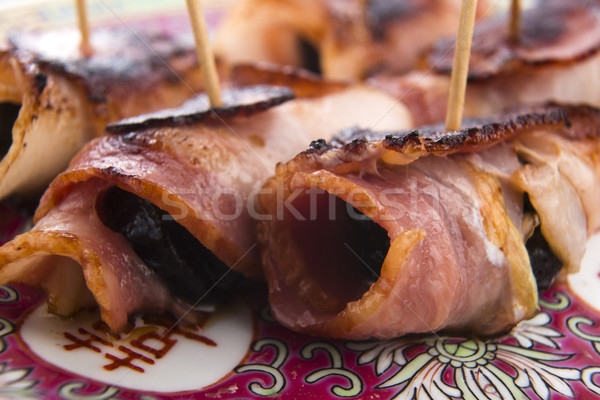 Baked prunes in bacon on a plate Stock photo © joannawnuk