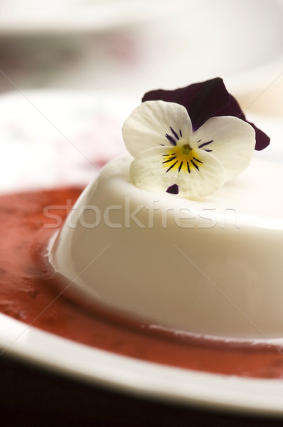 Stock photo: Vanilla panna cotta with berry sauce and spring flower