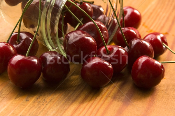 Cherry in glass jar isolated on the wooden background Stock photo © joannawnuk