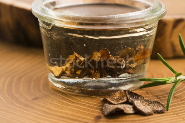 Sliced black truffle in olive oil in small jar and fresh rosemar Stock photo © joannawnuk