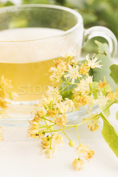 teapot and cup with linden tea and flowers Stock photo © joannawnuk