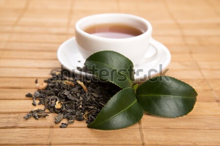 A cup of green tea with freh leaves Stock photo © joannawnuk