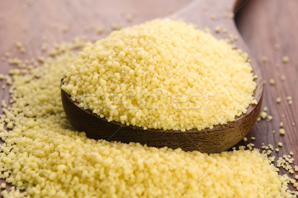 couscous in wooden spoon on kitchen table Stock photo © joannawnuk