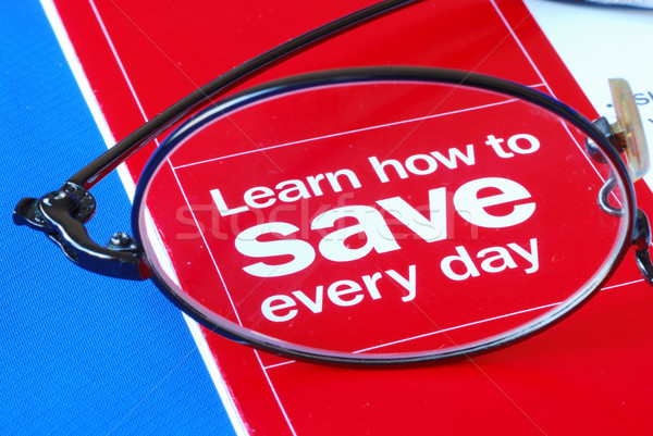 Stock photo: Focus on learning how to save money everyday isolated on blue