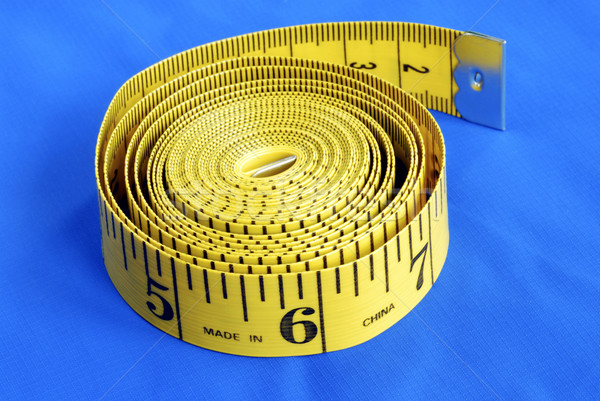 A coiled-like measuring tape isolated on blue background Stock photo © johnkwan