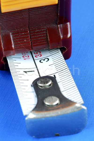 Focus on the one inch mark on the measuring tape isolated on blue Stock photo © johnkwan