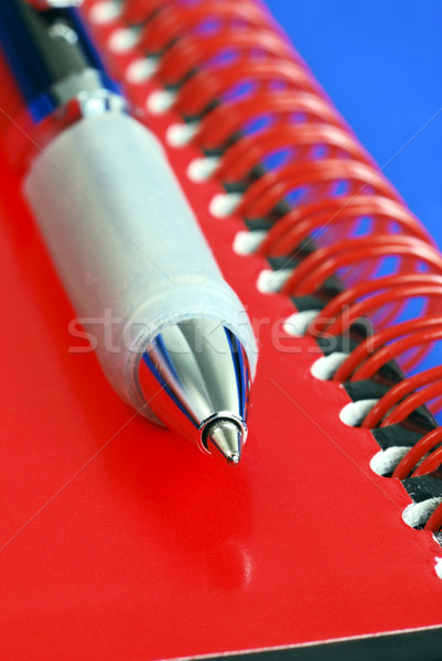 A pen on the top of a red note book isolated on blue Stock photo © johnkwan