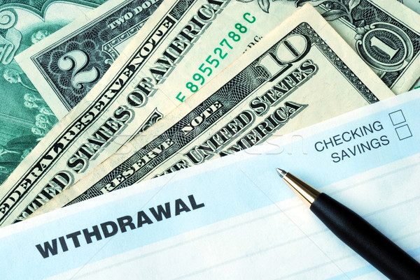 Stock photo: Fill the bank slip to withdraw some money
