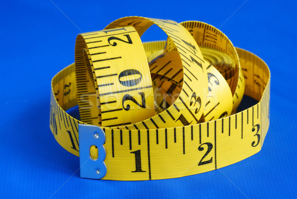 A measuring tape isolated on blue background Stock photo © johnkwan