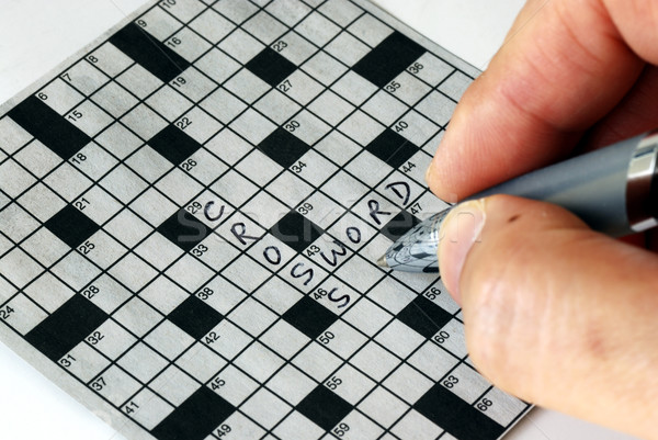 Solving the cross word puzzle from the newspaper Stock photo © johnkwan