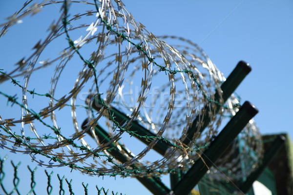 Stock photo: barbed wire against blue sky 