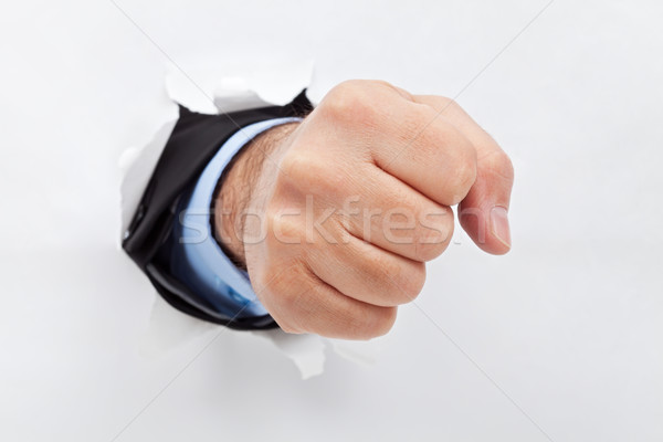 Businessman fist through the paper Stock photo © joseph73