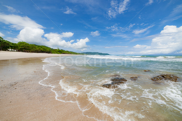 Waves sand beach and clouds sunny day Stock photo © Juhku