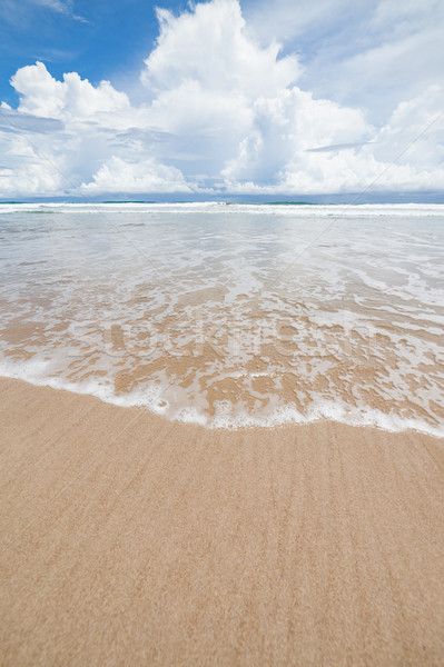 Waves sand beach and clouds sunny day Stock photo © Juhku