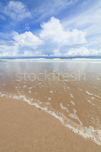 Waves sand beach and clouds sunny day Stock photo © Juhku